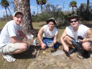 Three male students collecting samples.