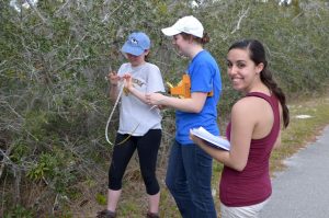 Three female students taking data in the field.