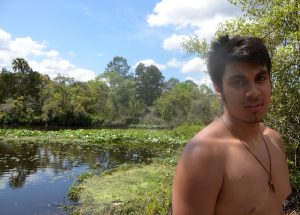 Male student with a pond for backdrop.